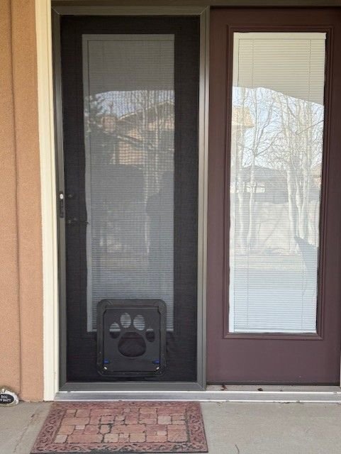 Paw-print pet door in a screen door